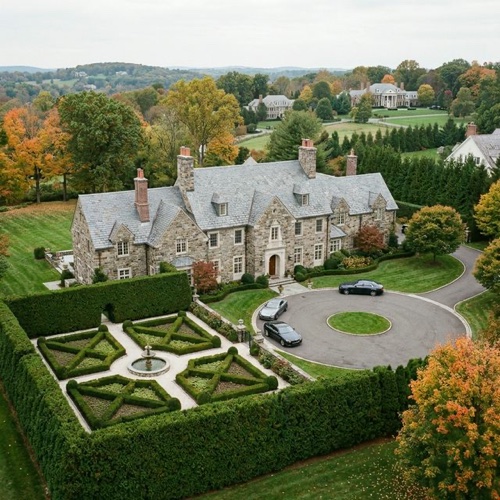 Aerial view of a stone manor estate with formal gardens and circle driveway in Short Hills New Jersey